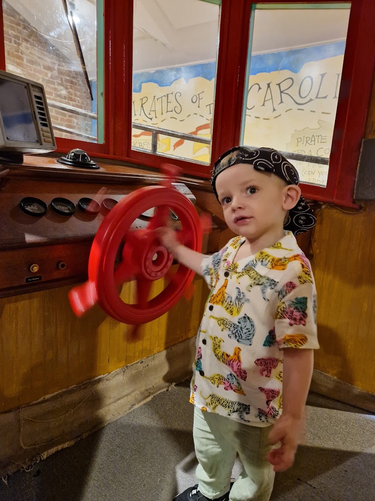 Child steering the ship at Charleston Children's Museum.