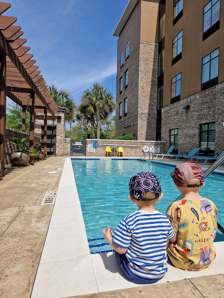 The kids are sitting next to the pool at Home2 Suites, Daniel Island, Charleston, South Carolina.